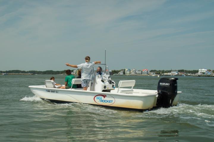 a man riding on the back of a boat in the water