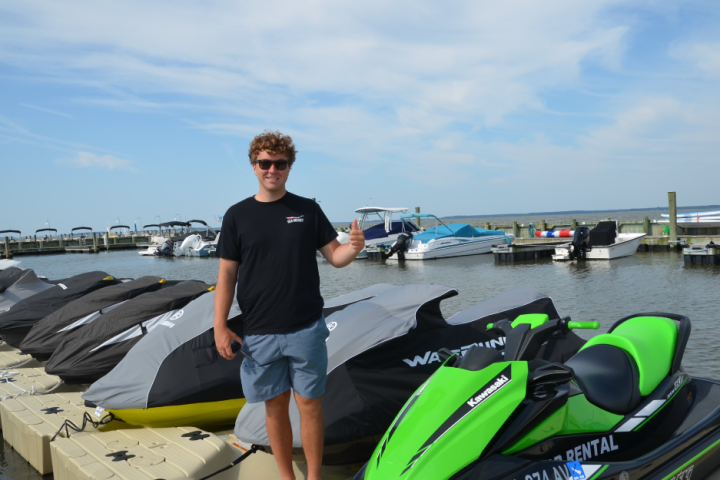 a person sitting on a motorcycle in front of a body of water