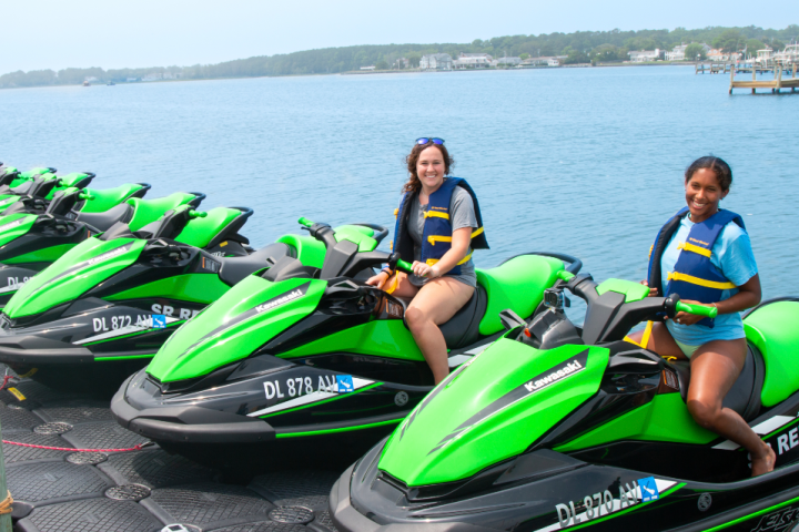 a green motorcycle parked on the side of the water