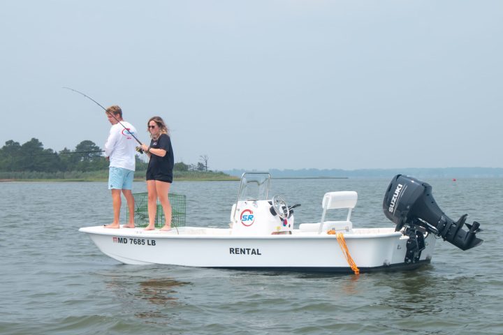 a man riding on the back of a boat in a body of water