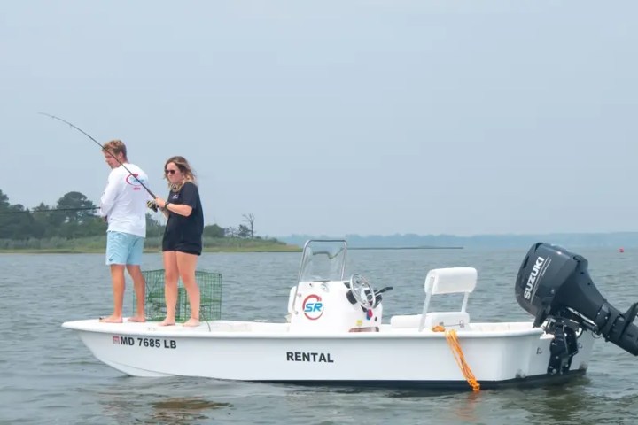 Two people fishing on a small motorboat in open water
