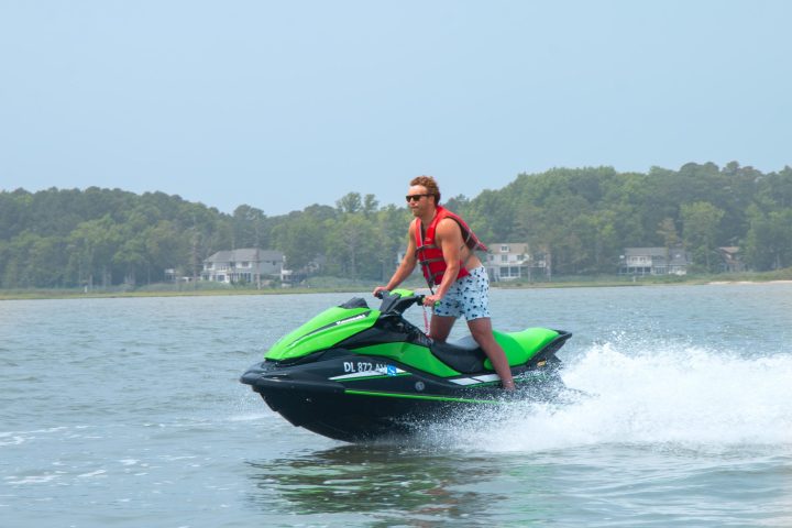 a man riding on the back of a boat in the water