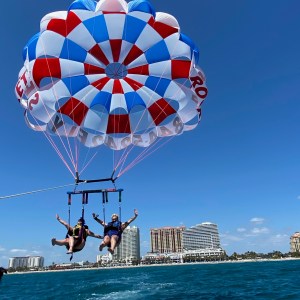 a person flying through the air while holding a blue umbrella