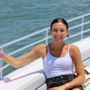 a woman sitting next to a body of water