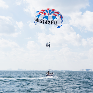 a man flying a kite in a large body of water