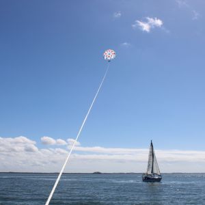 a man flying a kite in a boat on a body of water