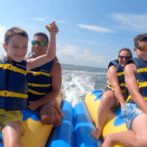 a young boy standing next to a body of water