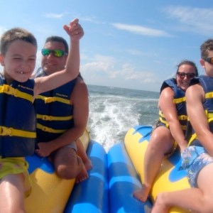 a young boy standing next to a body of water