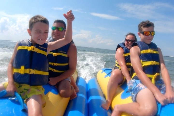 a young boy standing next to a body of water