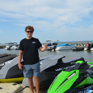 a person sitting on a motorcycle in front of a body of water