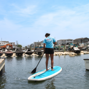 a person sitting on a dock next to a body of water