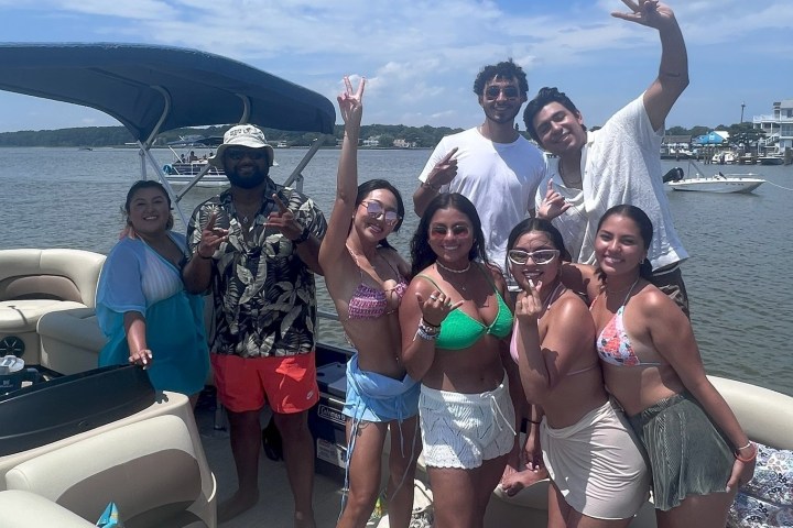 a group of people posing in front of a body of water