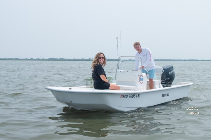 a man riding on the back of a boat in a body of water
