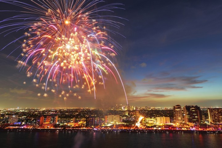 fireworks over a body of water with a city in the background