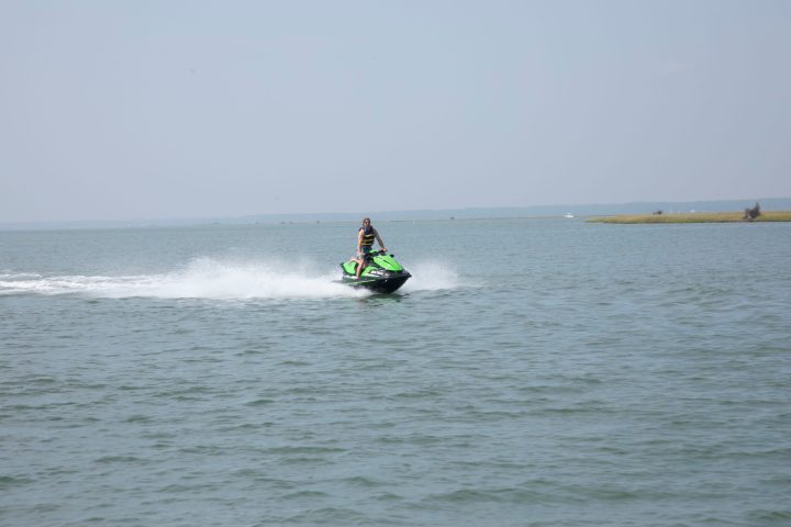 a man riding on the back of a boat in a body of water