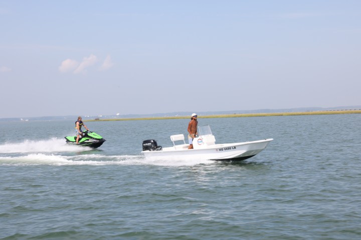 a group of people riding on the back of a boat in the water