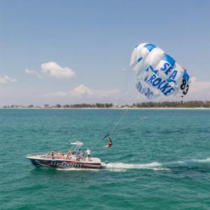 a man flying a kite in a boat on a body of water