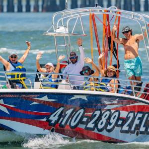 a group of people riding on the back of a boat in the water