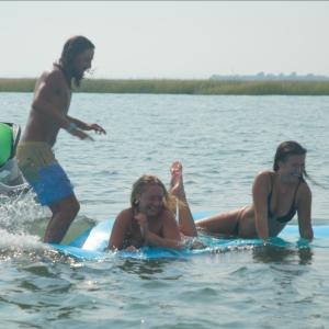 a young girl riding a wave on a surfboard in the water