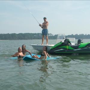 a man riding on the back of a boat in the water