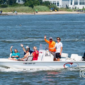 a group of people riding on the back of a boat in the water