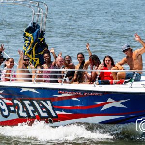 a group of people riding on the back of a boat in the water