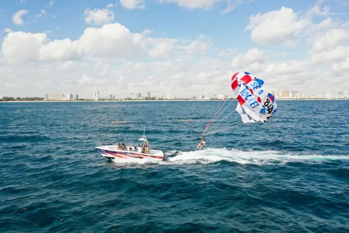 a man flying a kite in a boat on a body of water