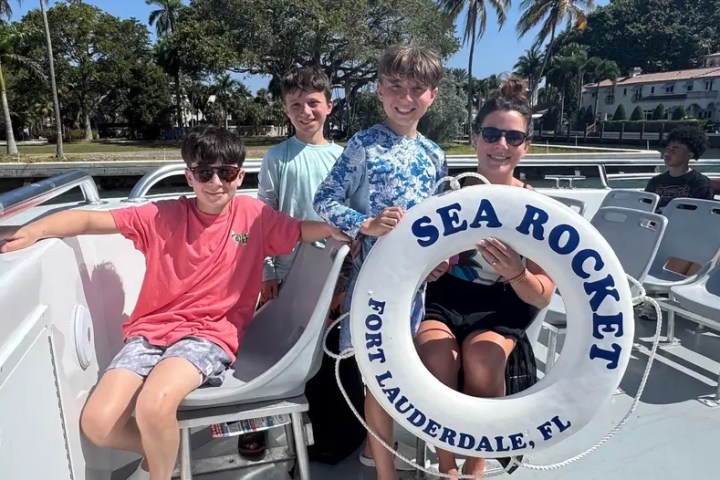 Four people on a boat holding a Sea Rocket lifebuoy in Fort Lauderdale, FL.