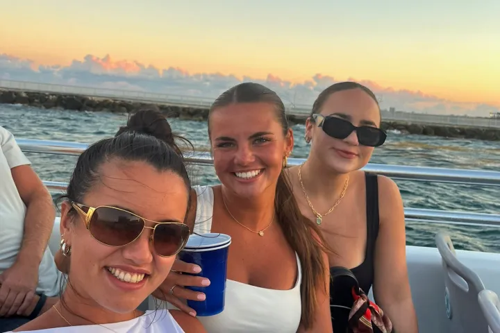 a couple of people that are sitting next to a body of water