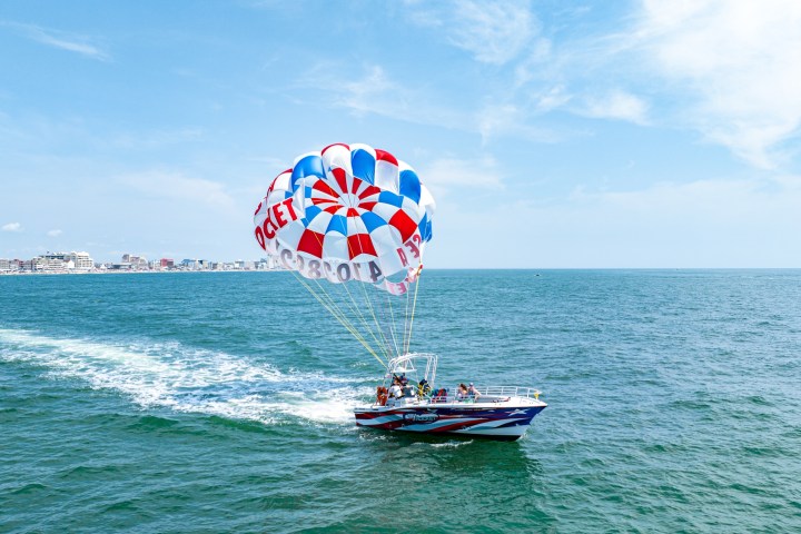 a person flying a kite in a boat on a body of water