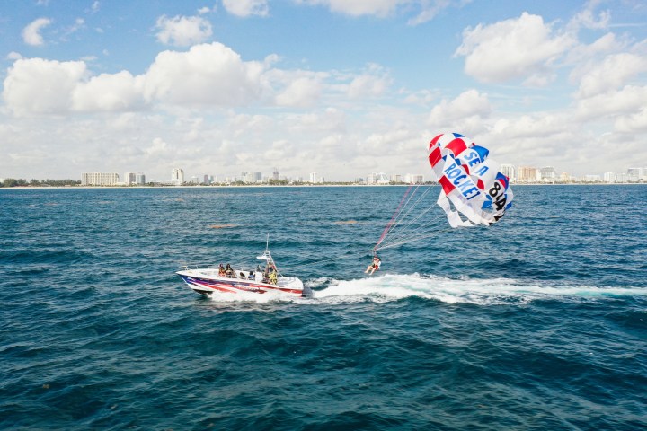 a man flying a kite in a boat on a body of water