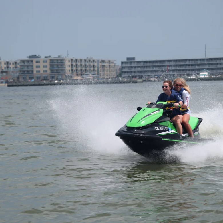 a man riding on the back of a boat in a body of water