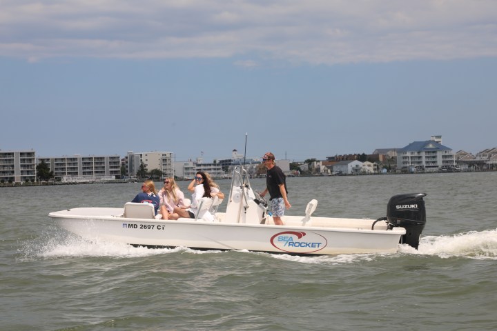 a group of people riding on the back of a boat in the water