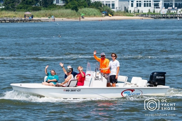 a group of people riding on the back of a boat in the water