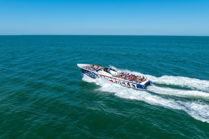 a man riding on the back of a boat in a body of water