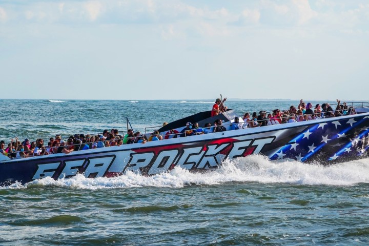 a group of people riding on the back of a boat in the water
