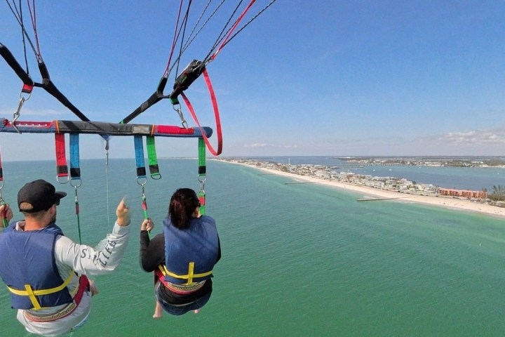 a man flying a kite in a boat on a body of water