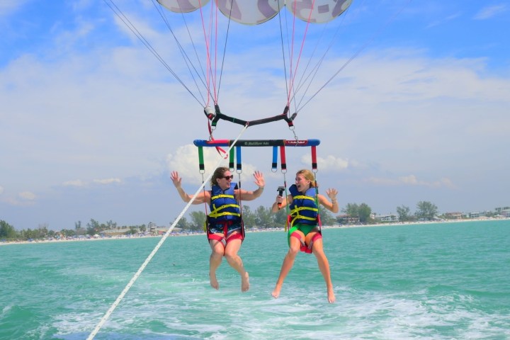 a person flying a kite in a large body of water
