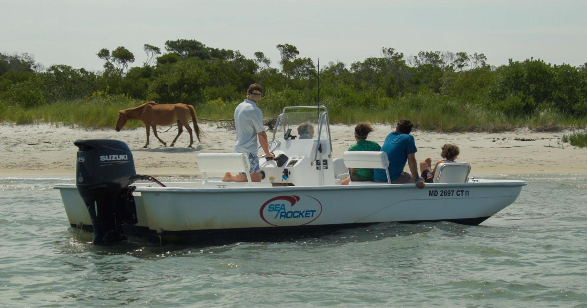a group of people riding on the back of a boat in the water