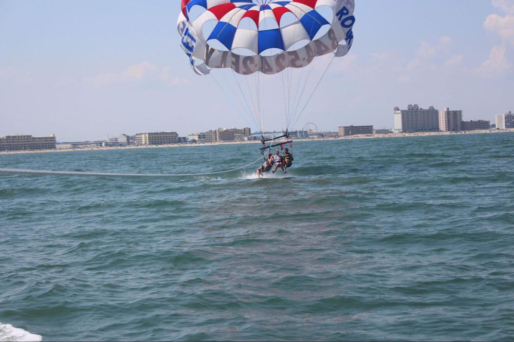 a person flying a kite in a large body of water