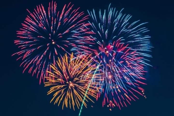 Colorful fireworks bursting in a dark night sky.