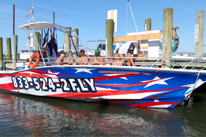 Speedboat with star-spangled design docked, people sitting aboard.