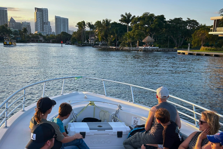 Group of people on a boat enjoying a city waterfront view.