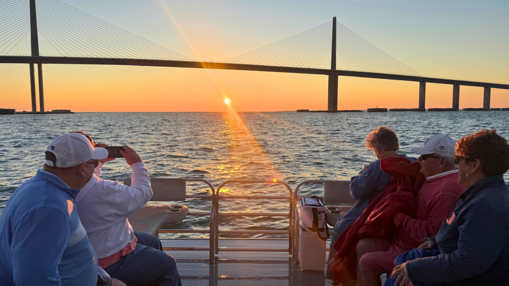  Private sunset cruise on Anna Maria Island with the Sunshine Skyway Bridge silhouetted against an orange Gulf of Mexico sky 