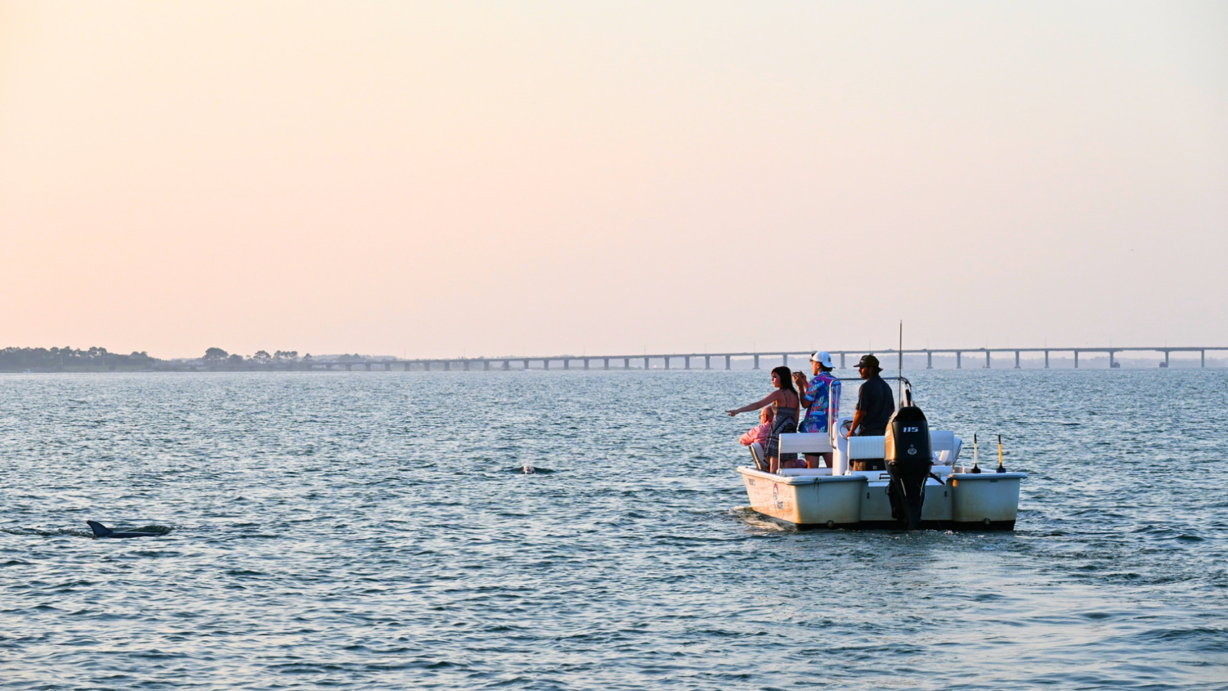 Dolphins jumping near a Sea Rocket boat during a golden hour cruise in Ocean City 